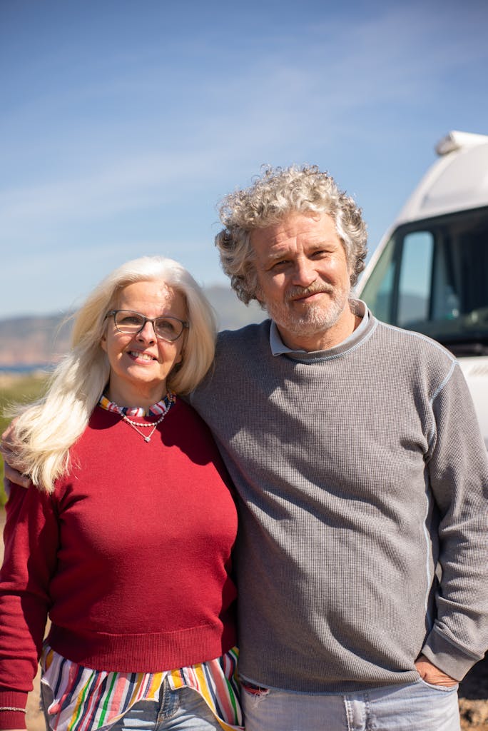 Senior couple smiling and embracing outdoors in Portugal, showcasing love and companionship.